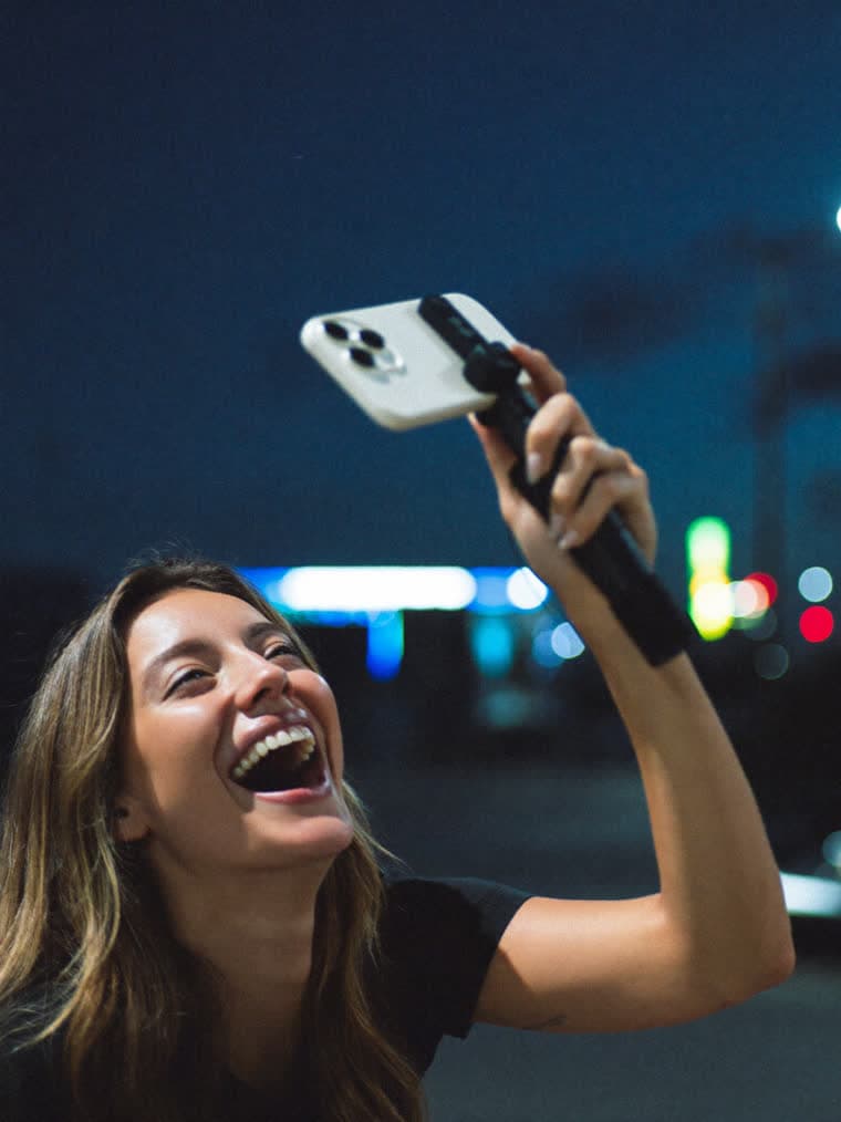 Vlogger filming herself at night, laughing